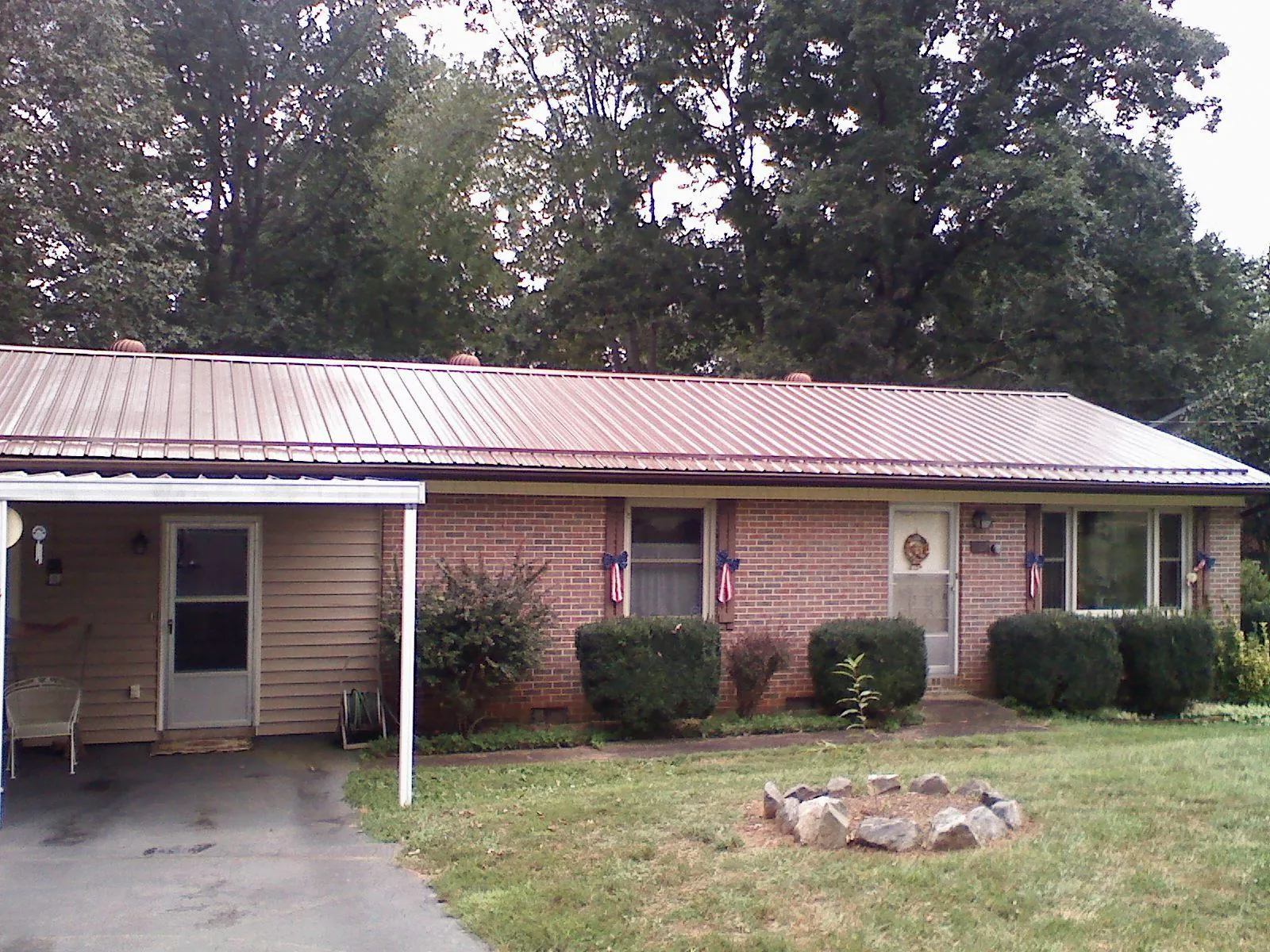Bronze metal roof and carport on a brick ranch home — Roof Repair work by our crew in Dawson